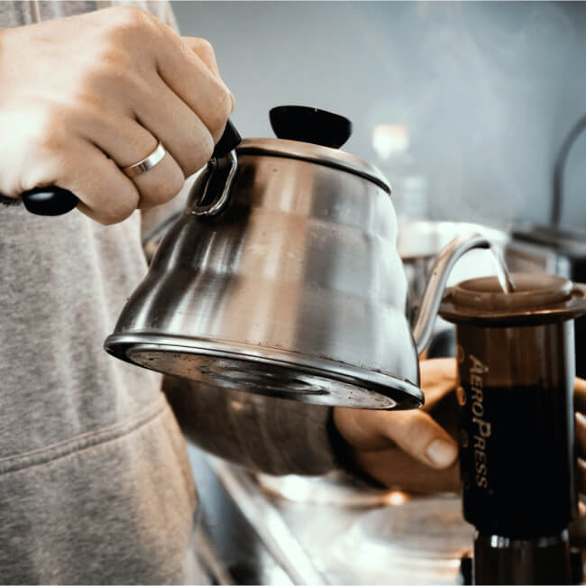 Aeropress relleno con agua con una tetera cuello cisne